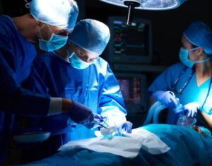 A team of three surgeons performing an operation in an operating room.